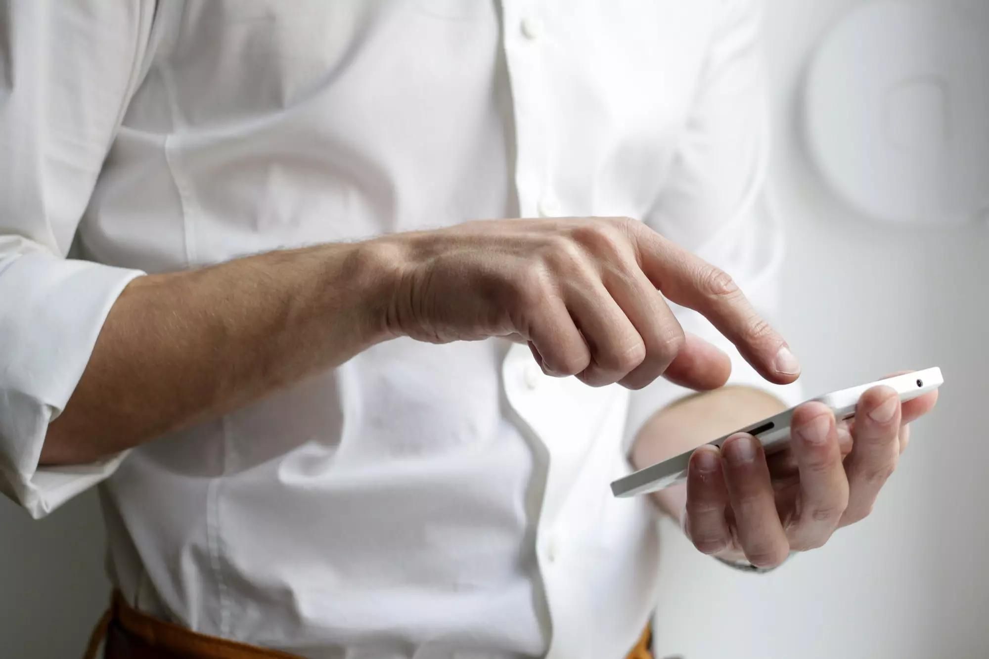 mężczyzna wskazujący palcem na telefon