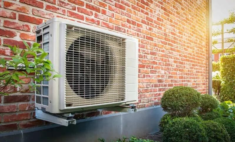 Pompa ciepła zainstalowana na zewnątrz budynku w słoneczny dzień